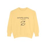 Currently cycling (the tank kind) premium crewneck sweatshirt in Butter, front view with the navy cycle arrows and doodle medaka print
