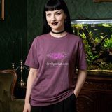 Woman with black hair and blunt bangs wearing the Nightshade logo tee in Berry, in a dark green Victorian parlor with a large planted aquarium
