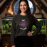 Woman with long dark curls wearing the Nocturne logo long sleeve tee in Black, in an attic study with a round moonlit window and a planted aquarium