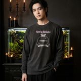 Man with swept-back black hair wearing the Lux in Tenebris long sleeve tee in Black, beside a large planted aquarium on a carved black cabinet with candles