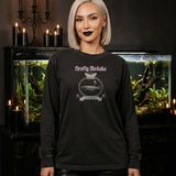 Woman with a platinum bob wearing the Lux in Tenebris long sleeve tee in Black, beside a large planted aquarium on a carved black cabinet with candles