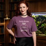 Woman with long red hair and an oxblood lip wearing the Lux in Tenebris tee in Berry, in a wood-paneled library with a large planted aquarium